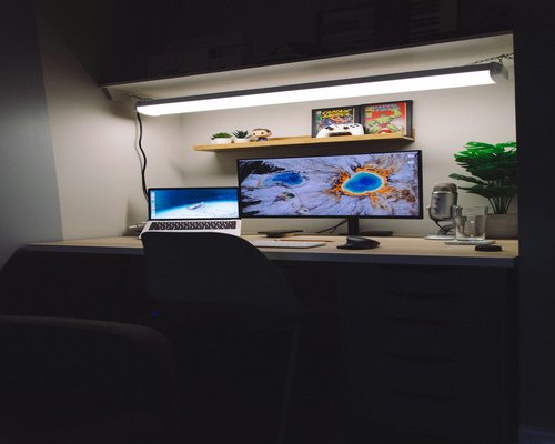 A detailed view of an ergonomic workstation with organized accessories and well-distributed ambient illumination
